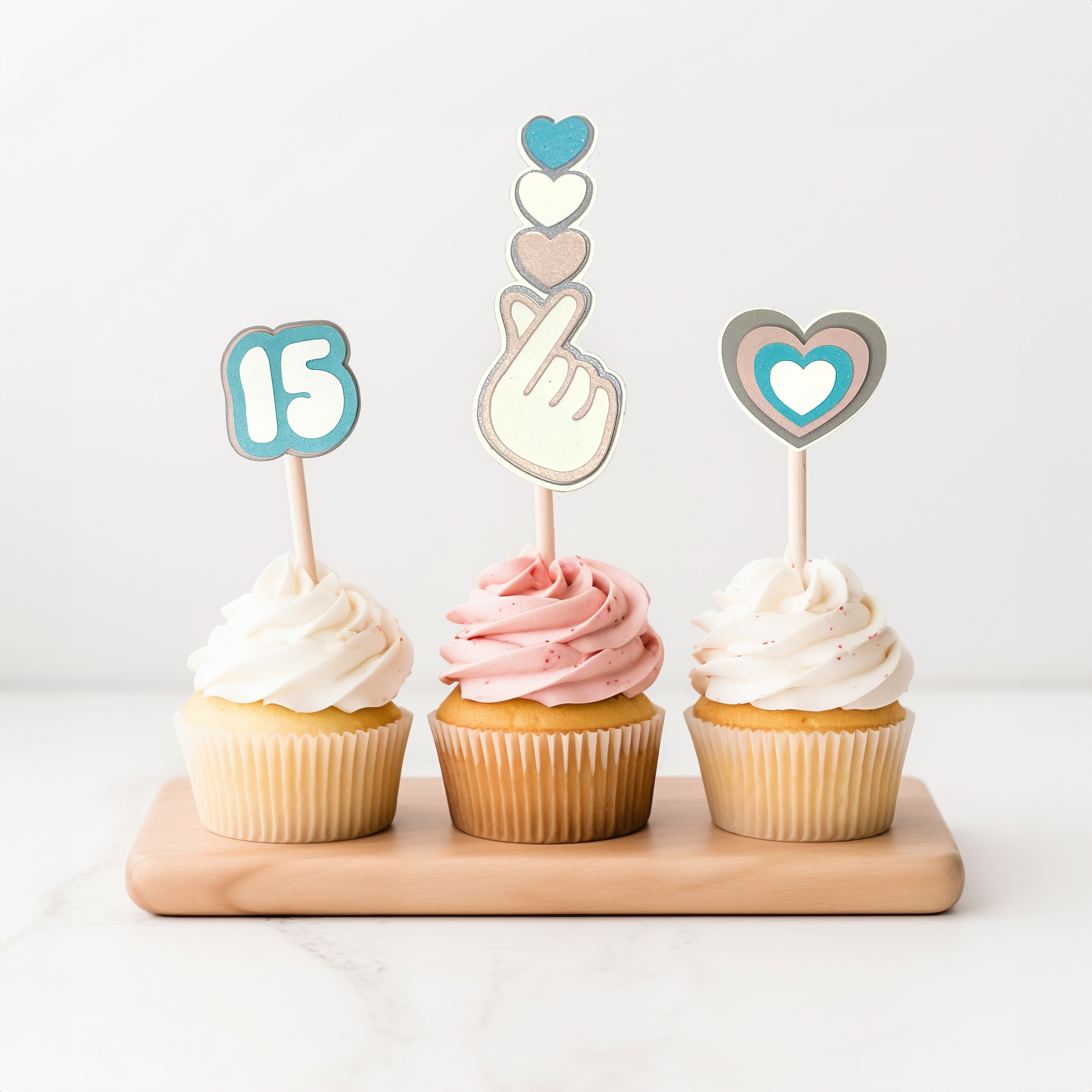 Pretty cupcakes with cute non-edible cake topper set with age, heart and finger heart designs